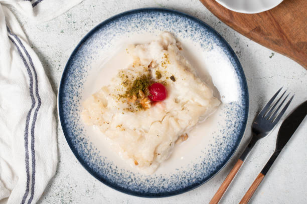 istock Gullac dessert with walnuts. Ramadan sweets. Traditional Turkish cuisine delicacies. Gullac dessert with cherry, pistachio and walnuts on gray background. Top view 1478017743