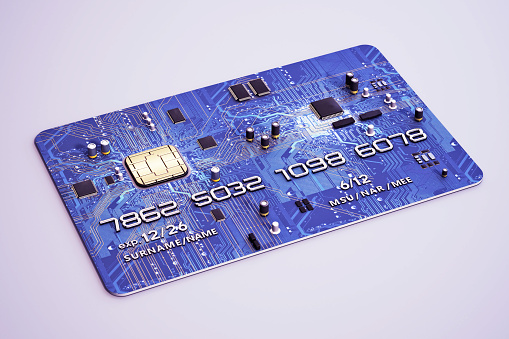 Electronic parts and chips on PCB textured credit card with fictitious information. Digital banking, finance and technology concept.