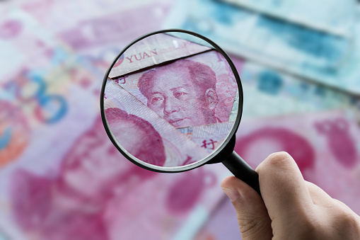 A magnifying glass over chinese yuan banknotes