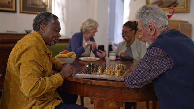 Senior men play chess while women are surfing the internet