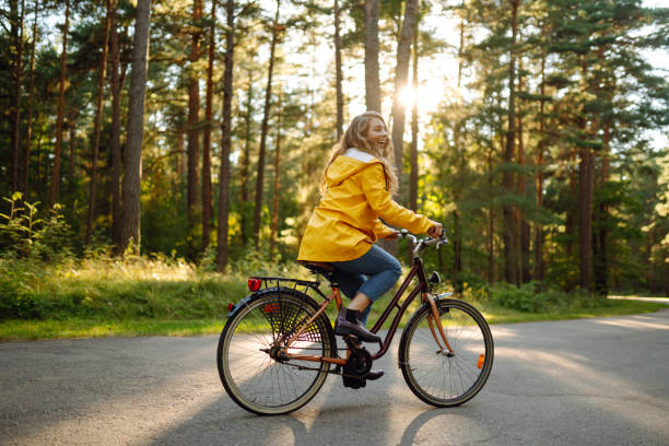 istock Smiling woman with curly hair in  a bicycle in a sunny park 1478020249
