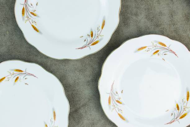 istock Set of three ceramic plates decorated with wheat illustrations displayed on a grey background 1478020551