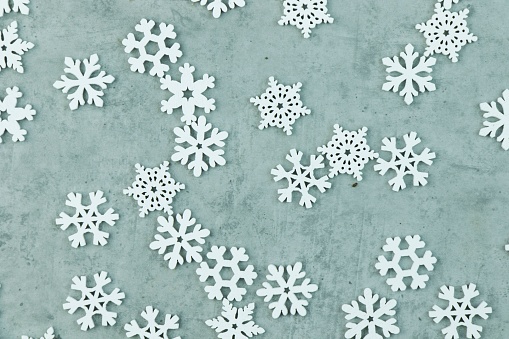 A handcrafted set of snowflakes arranged on a grey background