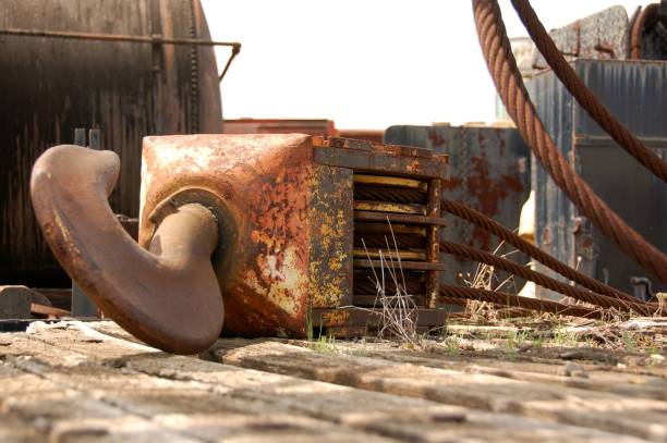 A close-up image of a rusty crane hook lying on the ground at a construction site