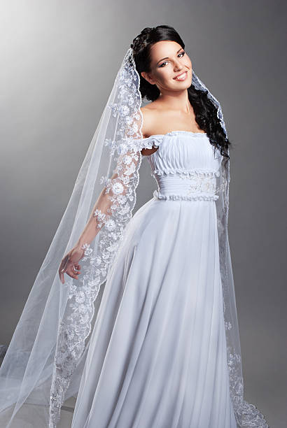 istock beautiful bride is standing in wedding dress 147802466