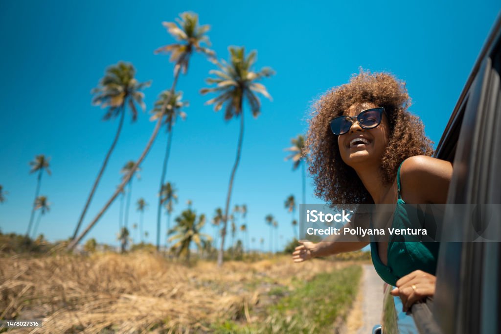 Woman looking out the car window Tropical beach road trip Road Trip Stock Photo