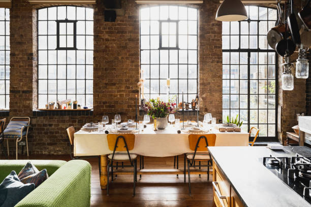 Dining table set for Christmas lunch backlit by sunlight streaming through large industrial style windows