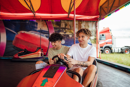 Group of teenagers enjoying a funfair in Newcastle, North East of England. They are on a dodgem ride laughing and having fun.