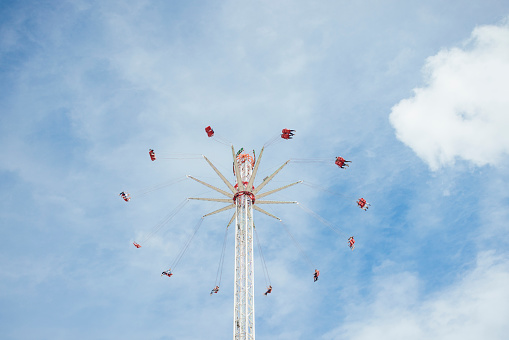 People flying in the air enjoying a fun ride at an amusement park - lifestyle concepts