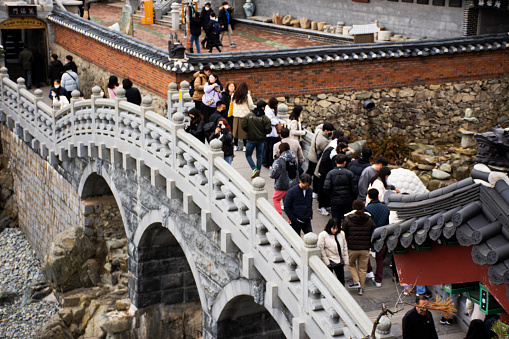 Korean people travelers walking crossing antique stone bridge travel visit praying blessing wish buddha holy in Haedong Yonggungsa temple at Gijang on February 18, 2023 in Busan or Pusan, South Korea