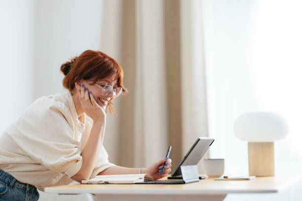 istock Smiling Female Student Using A Digital Tablet At Home 1478036516