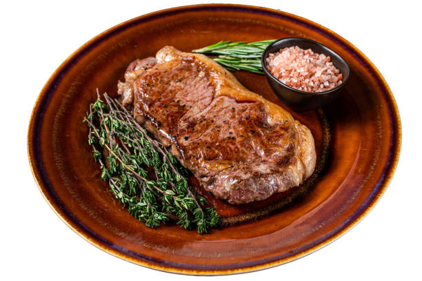 istock Roasted new york strip beef meat steak or striploin in a rustic plate.  Isolated on white background. 1478038709