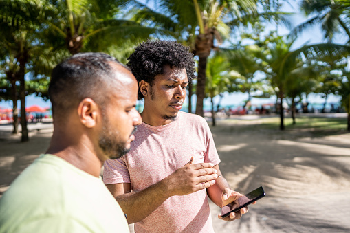 Man using smartphone asking for direction in a boardwalk