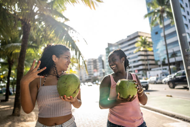 istock Friends walking in a boardwalk drinking coconut water 1478043967