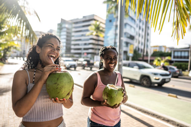 istock Friends walking in a boardwalk drinking coconut water 1478043990