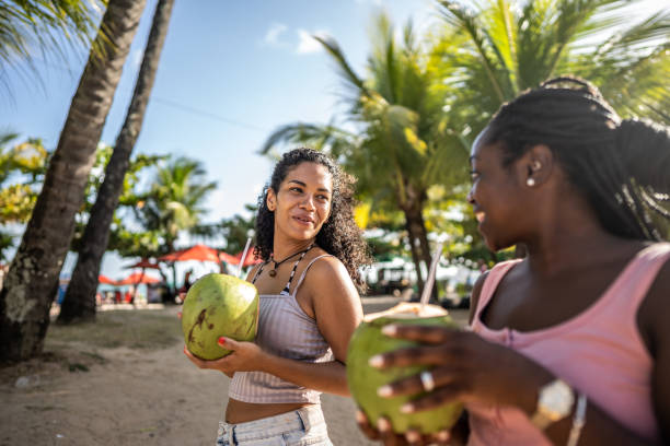 istock Friends walking in a boardwalk drinking coconut water 1478044033