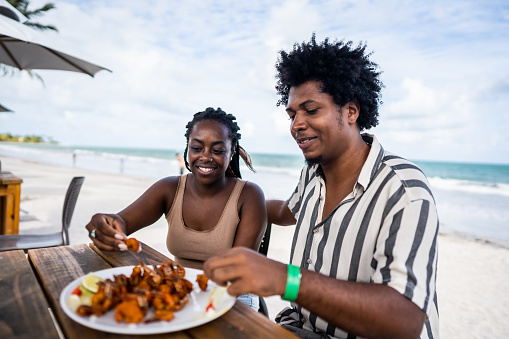 Mid adult couple eating in a restaurant at the beach
