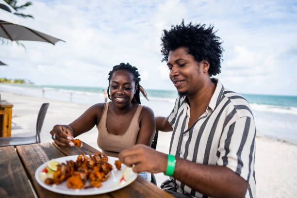 mid adult couple eating in a restaurant at the beach - couple restaurant day south america imagens e fotografias de stock