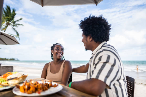 happy couple looking at each other in a restaurant at the beach - couple restaurant day south america imagens e fotografias de stock