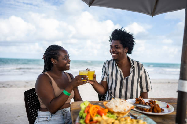 mid adult couple doing a celebratory toast in a restaurant at the beach - couple restaurant day south america imagens e fotografias de stock