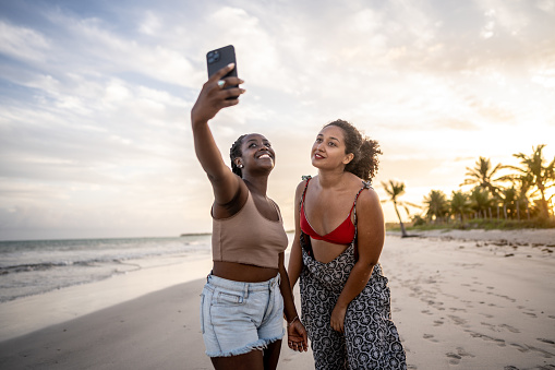 Friends taking a selfie using mobile phone at the beach