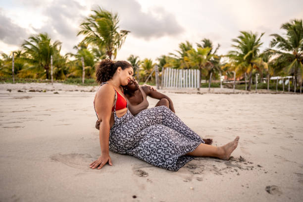 istock Female friends sitting relaxing on the beach 1478045778
