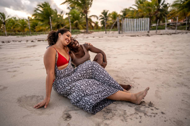 Female friends sitting enjoying sunset at the beach