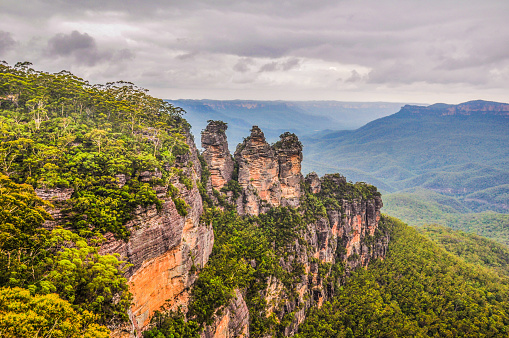 A beautiful view of The Three Sisters at Scenic Way, Blue Mountain, NSW, Australia. A majestic mountains with blue layered colour and orangey rocks landscape taken from the distance with Nikon Camera.