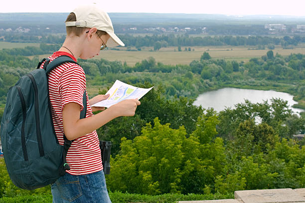 Boy with binoculars, backpack and map stock photo