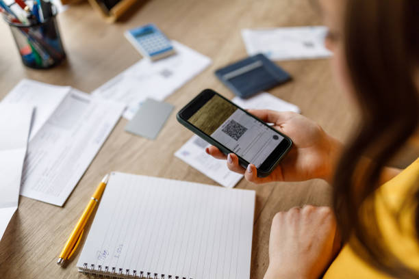 istock Young woman scanning the QR code on the financial bill with smart phone when digitally 1478050231