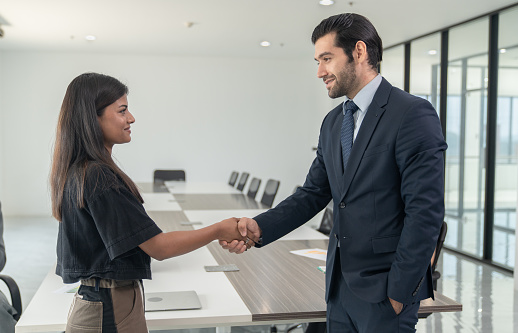 Two business men shaking hands after talking about the agreement.