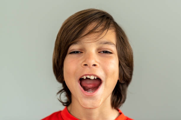 portrait d’un garçon avec une des dents de devant cassée - screaming little boys child human teeth photos et images de collection