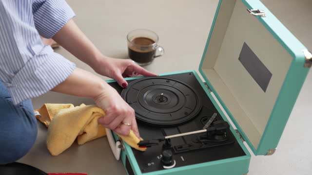 Woman dusts off a record player