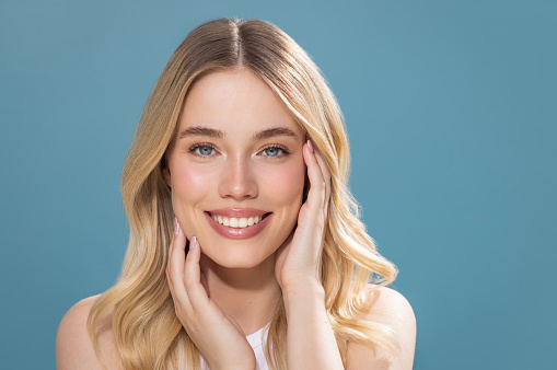 Studio shot of a beautiful natural blonde woman with perfect skin, enjoying in her perfect skin.