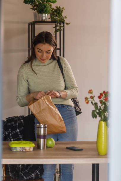 istock Young woman packing a lunch to bring to work 1478059325