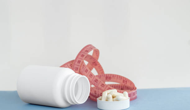 istock bottle with pills and measuring tape stethoscope isolated 1478060609