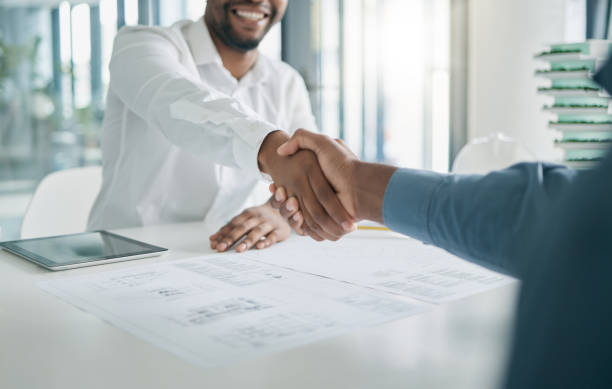 Black man, shaking hands and architecture with architect hiring, interview and onboarding, office and blueprint plan. Human resources, recruitment and partnership with deal, contract and thank you