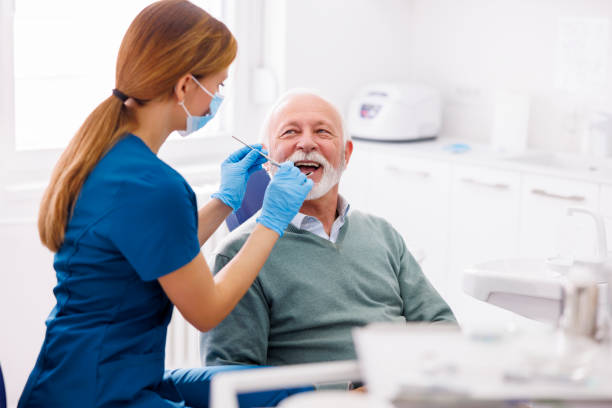 Doctor checking up patient's teeth at dentist office stock photo