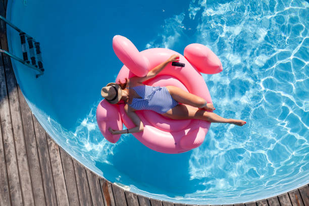 istock Woman relaxing on pink flamingo inflatable ring 1478068430