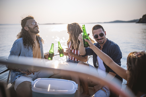 Photo of friends hangout on speed boat in Aegean sea ,they relax and enjoy drinks.