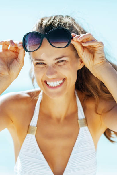 istock happy young woman with eyeglasses on beach 1478074971