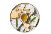 French Cheese platter with camembert, brie, Gorgonzola, parmesan, honey, nuts and herbs.  Isolated on white background.