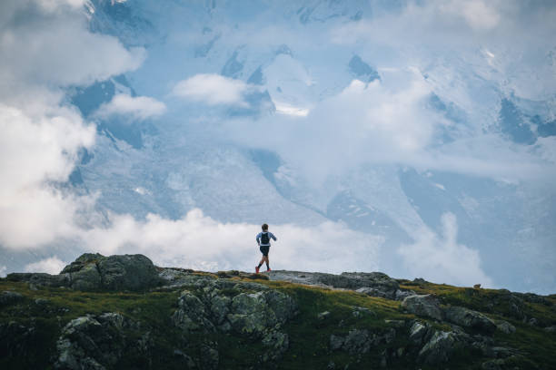 istock Trail runner bounds along mountain trail below clouds 1478078108