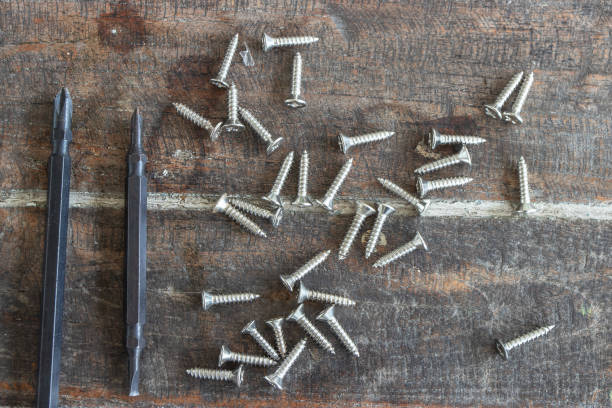istock Screwdrivers and screws on wooden background. 1478081701