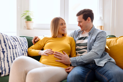 Pregnant woman enjoying with her husband at home