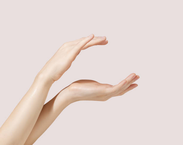 Hand model holding a cosmetic jar on a pink background for cosmetic advertising stock photo