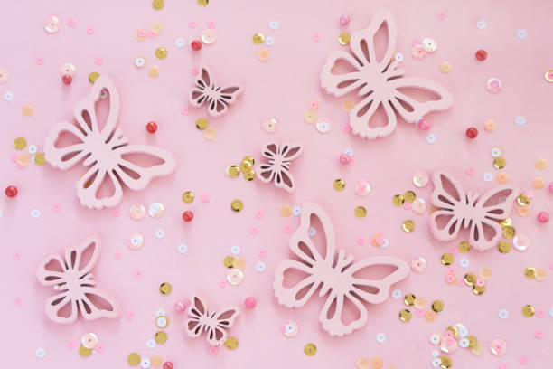 butterflies and confetti on pink background monochromeon. Top view. Spring concept. Flat lay