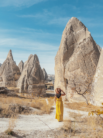 Mujer joven en Capadocia contempla las formaciones rocosas, camina alrededor photo
