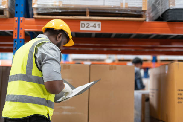istock African worker holding folders for checking and inspecting on site warehouse area for shipping transportation. Concept people operation in heavy industrial. 1478100461