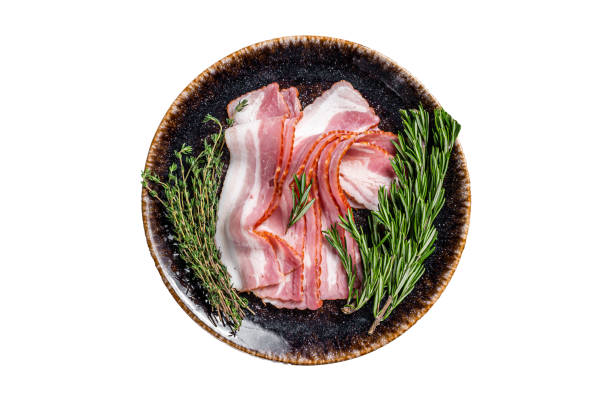 istock Raw sliced bacon ready for cooking with herbs.  Isolated on white background. 1478101201